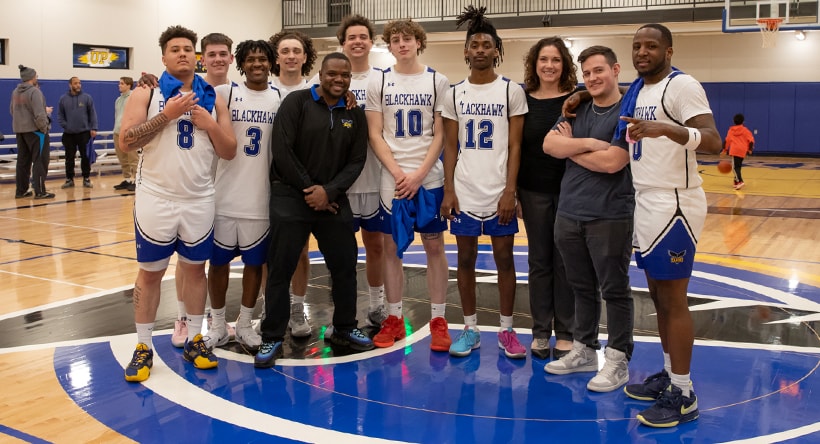 Talons Men's Basketball team posing at center court